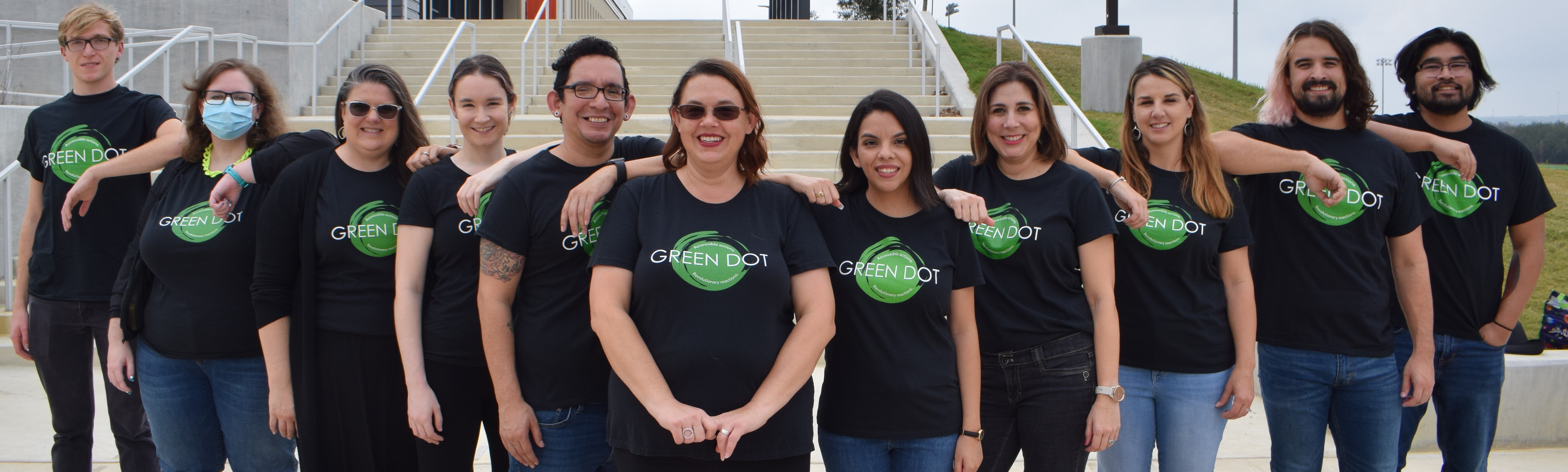 People standing in front of stairs in Green Dot shirts